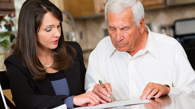 older man signing forms with funeral director